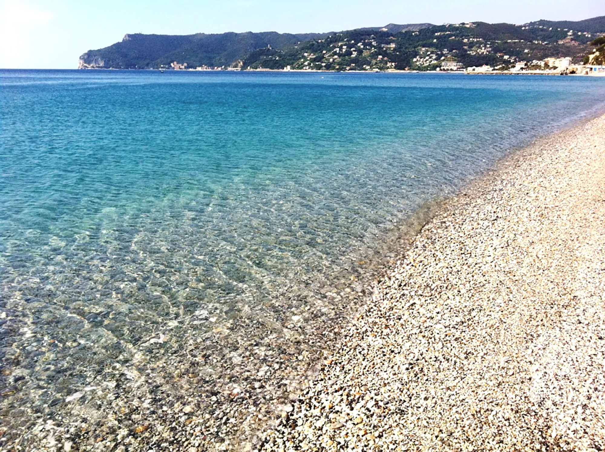 In the picture a glimpse of the beach of Spotorno and the sea with the promontory in the background